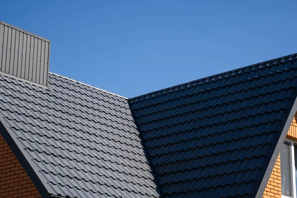 Серая гофрированная металлическая крыша, установленная на современном доме. Крыша из гофрированного листа. Крыша металлического профиля волнистой формы. Современная крыша из металла. Металлическая кровля. — стоковое фото