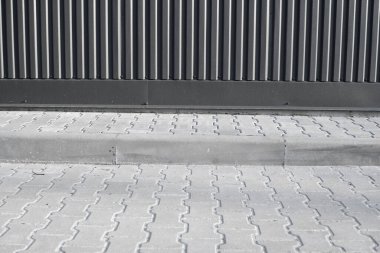 Endüstriyel binanın yakınındaki bir sokakta tuğla döşeme taşı. Arka plan olarak şehir dokusu.