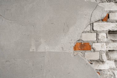 Parçalanmış beton duvarın altında beyaz tuğlalar..