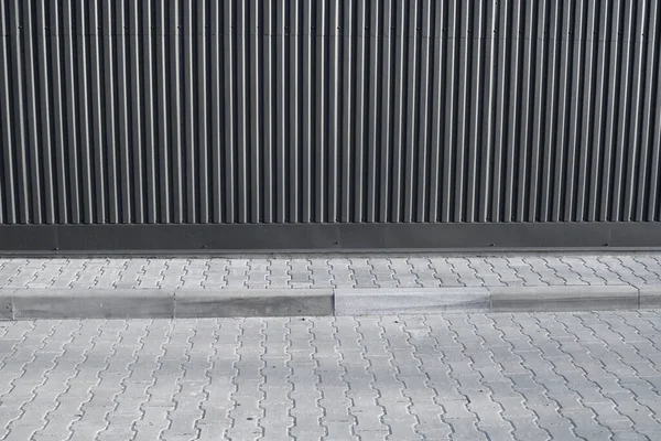Ladrillo pavimento de baldosas en una calle cerca de edificio industrial. Textura urbana como fondo. — Foto de Stock