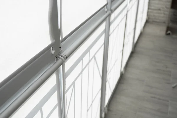 Tende a rullo in tessuto bianco sulla finestra di plastica su un balcone nel soggiorno. — Foto Stock
