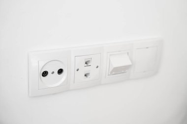 TV, SAT ve internet portlarına sahip modern beyaz duvar prizleri minimal iç tasarıma monte edildi.