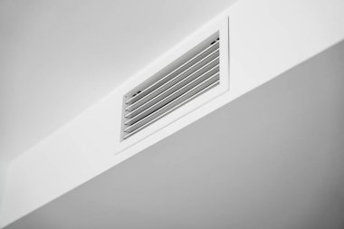 Minimalist modern bir iç mekâna kusursuz bir şekilde inşa edilmiş, havalandırma ve temiz mimari hatları ön plana çıkaran beyaz bir tavan menfezi..