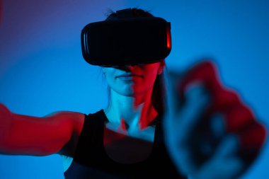 Bir kadın mühendis, VR kulaklık kullanarak gelişmiş sanal arayüzleri keşfediyor, gelecekteki teknolojiyi ve yenilikçi dijital ortamları deneyimliyor..