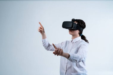 Sanal dünyayla etkileşim kurmak için yukarı bakan VR kulaklıklı bir kadın. Asgari beyaz arkaplan ve fütüristik sürükleyici teknoloji kavramı.