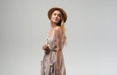 Açık yaz elbisesi ve hasır şapka giyen genç bir kadın yeniden kullanılabilir bir alışveriş çantası ve ekmek tutuyor. Çevre dostu market alışverişi, sürdürülebilir yaşam tarzı, sıfır atık alışkanlığı ve bilinçli tüketim kavramı.