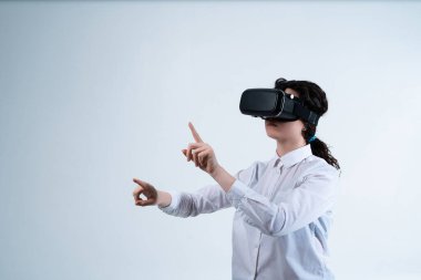 VR kulaklık takan ve sanal arayüzle iki elini de kullanan bir kadın kullanıcı. Temiz beyaz arkaplan ve sürükleyici dijital teknoloji kavramı.