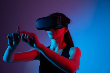 VR kulaklık takan ve yatay geçiş hareketi yapan bir kadın. Jest navigasyon, hareket takip, derin etkileşim ve modern dijital teknoloji kavramı.