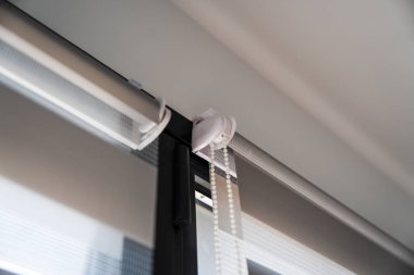 Çağdaş zebra silindirinin yakın çekimi, paten sistemini vurgulayan, parantez takan ve ışık yayılımı ve mahremiyet için kullanılan katmanlı kumaş yapısını belirleyen kurulumu kapatır.