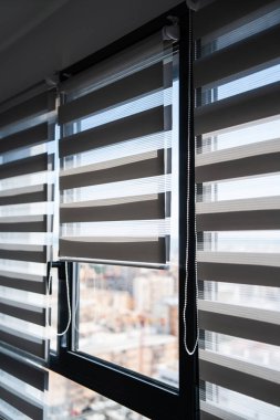 Zebra panjurlarıyla donatılmış geniş bir iç pencere, yumuşak kentsel manzarayı, modern ev, apartman ve gayrimenkul kavramlarını gözler önüne sererken kontrollü gün ışığı sağlıyor..