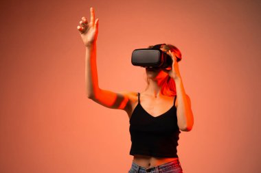 Kadın mühendis sanal ortamda yukarı doğru sanal gerçeklik teknolojisi kullanarak uzanıyor. Yenilik kavramı, metatik etkileşim, gelecekteki dijital deneyim ve yüksek teknoloji keşifleri.