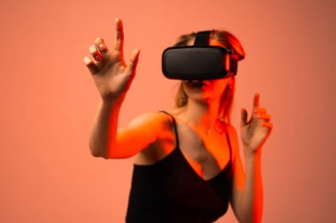 Sanal gerçekliğin içinde el hareketlerini kullanan bir kadının yakın plan görüntüsü. Dijital etkileşim kavramı, dolambaçlı deneyim, yenilik, metaevren ve gelecekteki teknoloji tasarımı.