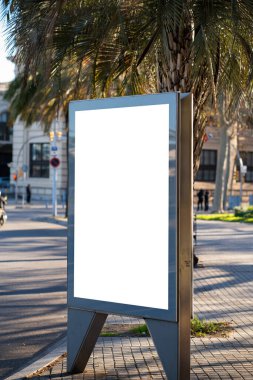 Boş bir açık hava reklam panosu bir şehir caddesinde duruyor, promosyon kampanyaları, pazarlama mesajları, duyurular veya güneşli bir günde markalaşma için izole bir kopya alanı sunuyor.