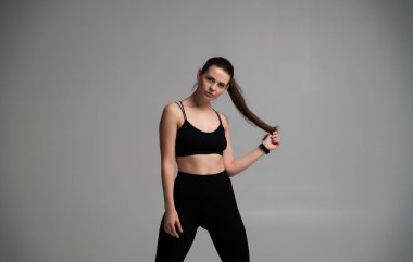 Siyah etek giyen, at kuyruğu tutan, spor, sağlık, vücut güçlendirme, güç ve spor kavramlarını taşıyan, antrenman veya antrenman için hazır bir kadın.