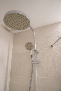 Modern krom duş başlıkları şık bir banyo içinde ferahlatıcı ve rahatlatıcı bir deneyim sağlar, hijyen, temizlik ve çağdaş ev tasarımını vurgular.