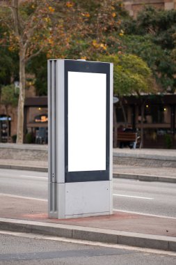 Boş beyaz açık hava reklam mupi bir şehir caddesinin yanında, markalaşma, pazarlama, promosyonlar ve ticari kentsel alanda kamu bilgilendirme kampanyaları için izole kopya alanı sunuyor