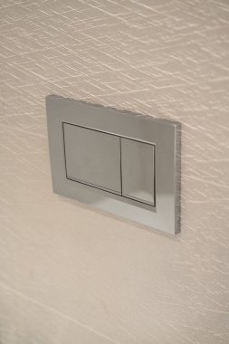 Duvara çift katlı krom renkli floş plaka, modern banyo tasarımı ve verimli temizlik sistemi için su tasarrufu özellikleri sunuyor, hijyen ve sürdürülebilirliği artırıyor