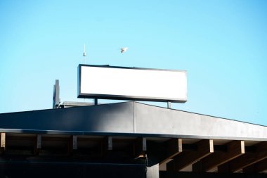 Açık mavi gökyüzüne karşı boş yatay çatı reklam, damgalama veya kentsel bir ortamda promosyon mesajlaşması için açık, en az açık kopya alanı sağlar.
