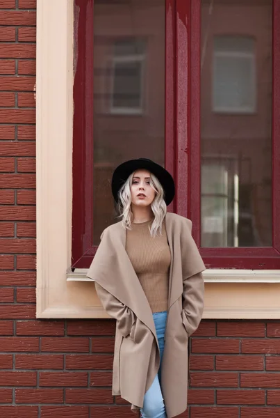 Ragazza bionda nel cappotto posa fuori — Foto Stock