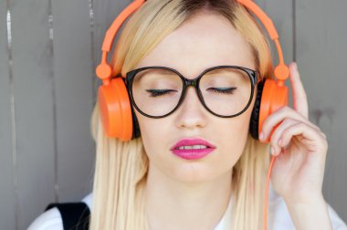 müzik rahatlatıcı, turuncu kulaklıklar, sokak çekimi, müzik enerji, yaşam tarzı, Avrupa ya da Amerikan tarzı, müzik, keyfi kız kız açık ses, gün ışığı, açık havada