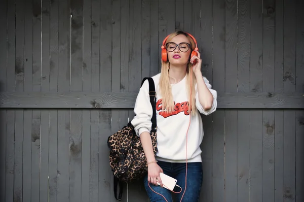 Girl listening to music, girl enjoying music, relaxing, orange headphones, street shoot, music energy, lifestyle, european or american style, clear sound, sunshine, outdoors — Stock Photo, Image