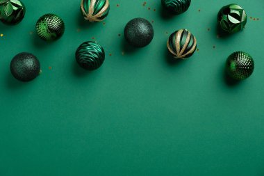 Yeşil arka planda Noel topları süslemesi. Xmas çerçeve kenarı, yukarıdan görüş, düz yatış. Noel tebrik kartı maketi