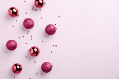 Noel kartı. Pastel pembe arka planda Noel topları süslemesi. Düz konum, üst görünüm, kopyalama alanı.