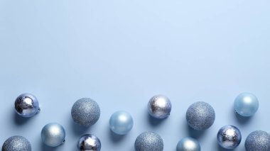 Pastel mavi arka planda mavi ve gümüş toplardan yapılmış Noel çerçevesi. Düz yerde, üst tarafta. Noel tebrik kartı şablonu, pankart modeli.