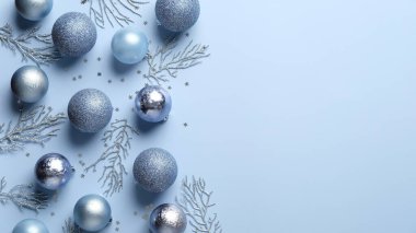Noel kompozisyonu. Mavi ve gümüş toplar, süslemeler, pastel mavi arka planda konfeti. Zarif, minimal stil. Xmas tebrik kartı şablonu, pankart modeli.