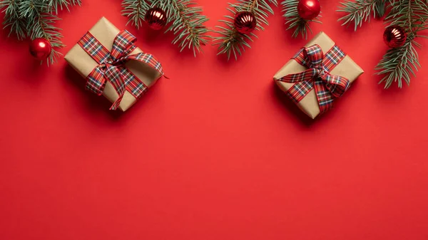 Χριστουγεννιάτικα Δώρα Και Κλαδιά Ελάτης Κόκκινο Φόντο Επίπεδο Lay Πάνω — Φωτογραφία Αρχείου