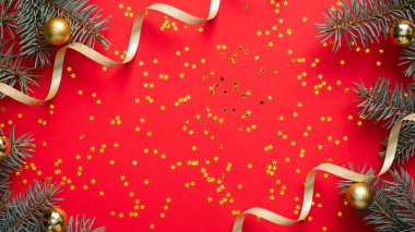 Christmas frame border. Fir tree branches decorated gold balls and ribbon, golden confetti stars on red background. Christmas, winter holiday, New Year celebration concept. Greeting card mockup.