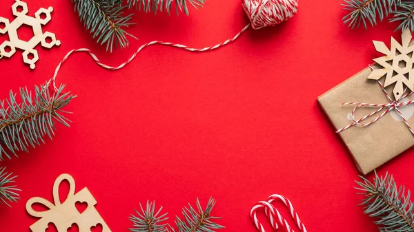 ヴィンテージクリスマス組成 木の枝 ギフトボックスは赤い背景のクラフト紙 ロープ キャンディーの缶を包んだ クリスマスフレームボーダー ポストカードデザインテンプレート — ストック写真