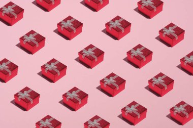Pembe arka planda kırmızı hediye kutularının deseni. Noel, Yeni Yıl veya Doğum Günü Kutlama Konsepti.
