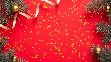 Noel çerçevesi köknar ağacı dalları, altın kurdele ve kırmızı arka planda parıldayan konfetiden yapılmış. Noel afişi, tebrik kartı şablonu. Düz yatış, üst görünüm.