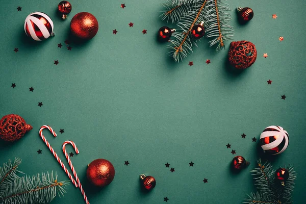 Kırmızı ve beyaz topları olan klasik Noel arkaplanı, köknar ağacı dalları, şeker kamışı, konfeti. Geçmiş Noel kartı şablonu.