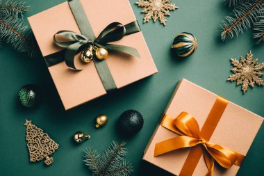 Zarif Noel süsleri ve koyu yeşil masada hediye kutuları. Düz yerde, üst tarafta. Eski, eski tarz Noel arkaplanı.