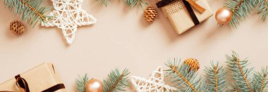 Modern Noel afişi tasarımı. Hediye kutuları, yıldız süslemeleri, köknar ağacı dalları, pastel bej arka planda toplar. İskandinav tarzı. Xmas başlık modeli