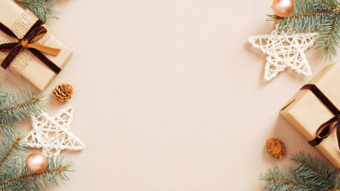 Noel aralığı. Noel ağacı dalları bej arka planda hediye kutuları, yıldızlar ve toplar süslemiştir. Düz konum, üst görünüm, kopyalama alanı. Noel afişi modeli, poster şablonu.