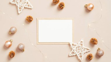 Boş kağıt kart ve topları ve yıldızları olan zarf, pastel bej arka planda Noel süslemeleri. Düz yerde, üst tarafta. Noel mektubu konsepti.