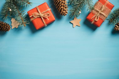Mutlu Noeller ve mutlu yıllar kartpostal şablonu. Kırmızı hediye kutuları, çam dalları ve koni, ahşap Xmas süslemeleri ile klasik stil düz konum.