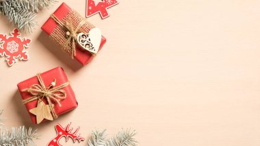 Noel kompozisyonu. Noel hediye kutuları, çam ağacı dalları, bej arka planda kırmızı el yapımı Noel süsleri. Antika, eski tarz. Düz konum, üst görünüm, kopyalama alanı.