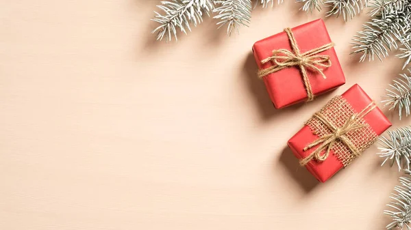 Rote Weihnachtsgeschenke Und Tannenzweige Auf Beigem Hintergrund Flache Lage Draufsicht — Stockfoto