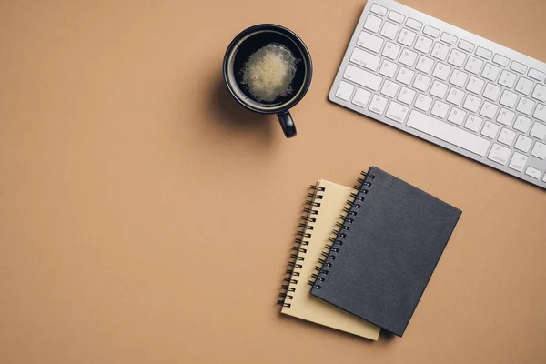 简约风格的写字台 配有一杯咖啡 褐色背景的纸质笔记本 业务概念 — 图库照片