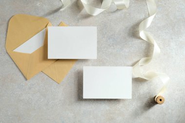 Düğün davetiyeleri ve zarflar beton masada. Düz yerde, üst tarafta. Aşk, aşk konsepti.