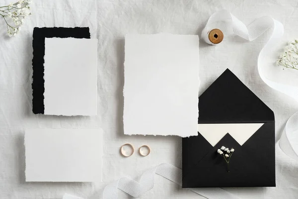 Wedding invites and envelopes on white background top view. Handmade wedding stationery set.