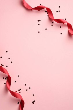 Sevgililer günün kutlu olsun. Kırmızı kurdeleli dikey pankart tasarımı ve pembe arka planda kalp şeklinde konfeti. Tatil broşürü tasarımı, tebrik kartı, hediye çeki şablonu. Asgari biçim.