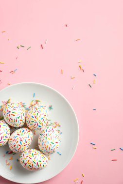 Pastel pembe arka planda renkli Paskalya yumurtaları. Mutlu Paskalyalar. Düz yatış, üst görünüm.