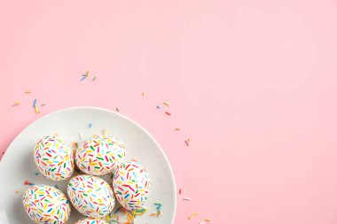 Pastel pembe arka planda renkli Paskalya yumurtaları. Mutlu Paskalyalar. Düz konum, üst görünüm, kopyalama alanı. Asgari biçim.