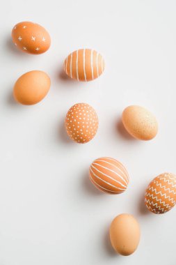 Beyaz arka planda basit bir Paskalya yumurtası. Düz, üst görünüm, dikey. Asgari biçim.