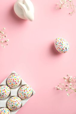 Mutlu Paskalyalar asgari konsepti. Düz uzanın, üst manzara Paskalya yumurtaları, tavşancık, pembe arka planda çiçekler.
